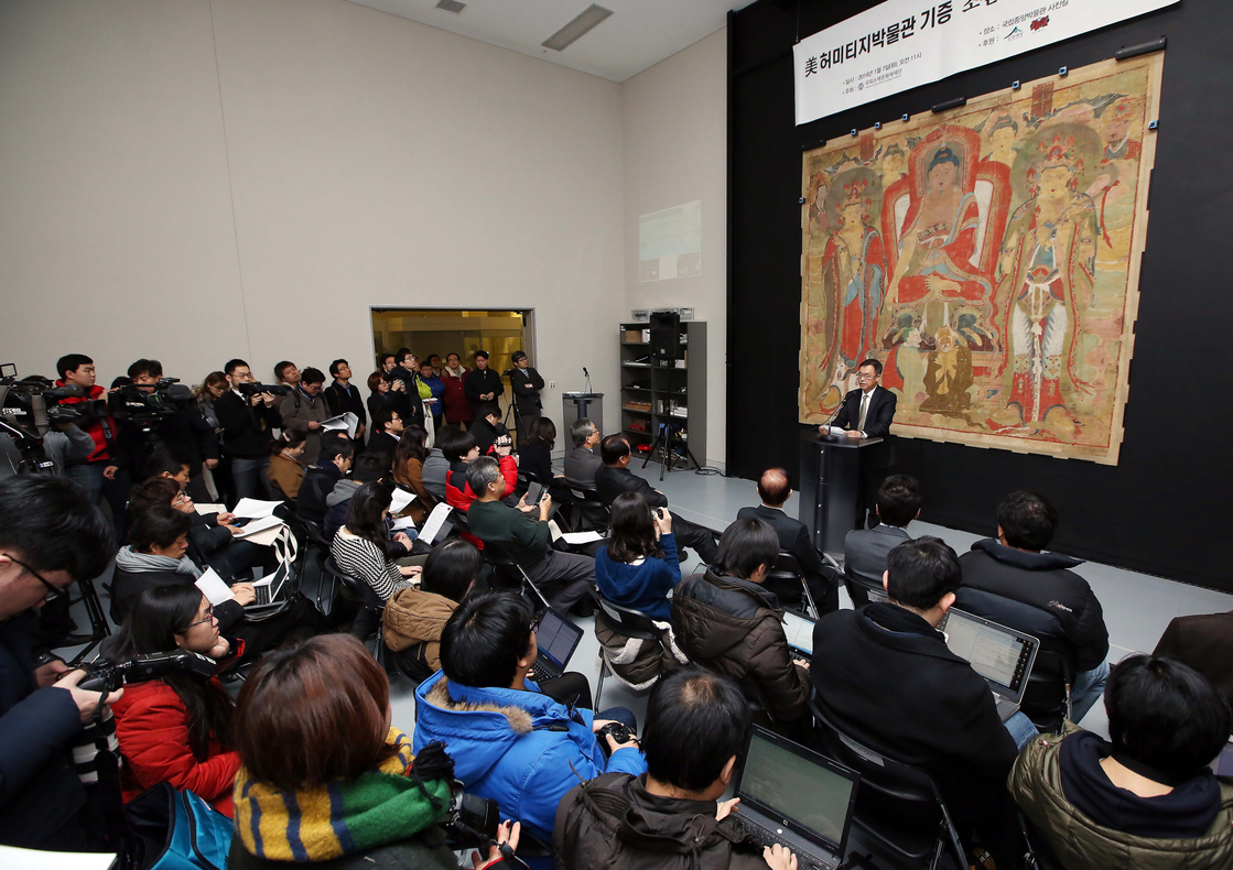 A representative from the CHA stands in front of NAME, the first item returned to Korea in 2014 as part of this project